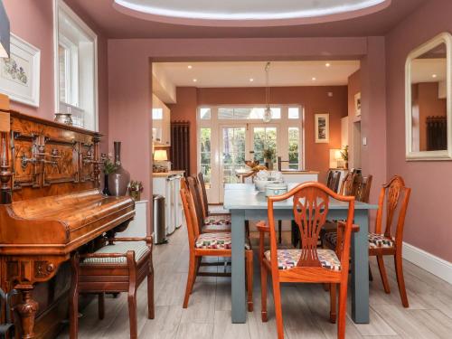 a dining room with a table and a piano at Harford House in York