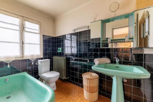 La salle de bains est pourvue d'un lavabo, de toilettes et d'une baignoire. dans l'établissement DIFY Chalet au Coeur de Megeve, à Megève