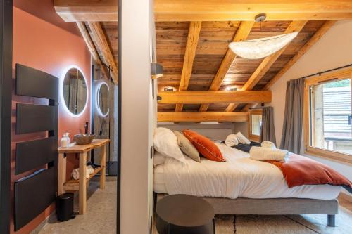 a bedroom with a bed and a wooden ceiling at SmartStay - Chalet Felix aux Confins in La Clusaz