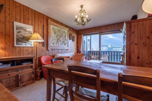 une salle à manger avec une grande table en bois et une fenêtre dans l'établissement SmartStay Mummery - Chamonix, à Chamonix-Mont-Blanc