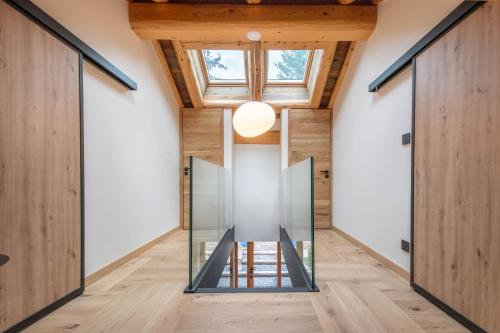 a glass elevator in a house with wooden ceilings at SmartStay - Chalet Felix aux Confins in La Clusaz