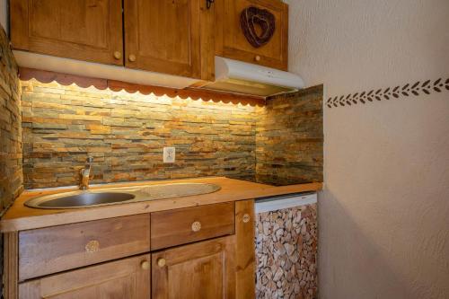 a kitchen with a sink and a brick wall at DIFY Gerets - St Gervais in Saint-Gervais-les-Bains