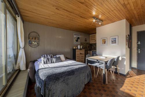 a bedroom with a bed and a table and a desk at DIFY Grand Soleil - Courchevel 1650 in Courchevel