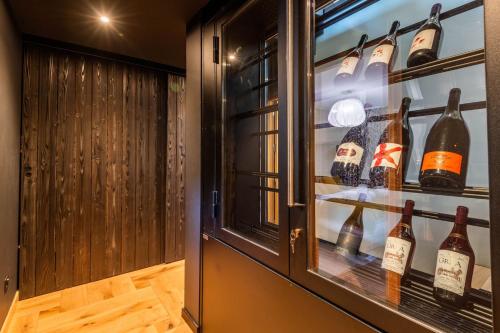 a display case in a wine cellar with wine bottles at SmartStay - Chalet Felix aux Confins in La Clusaz