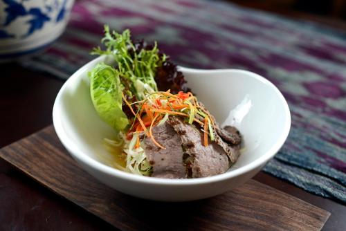 a bowl of food with meat and vegetables in it at Rumah Luwih Bali in Keramas