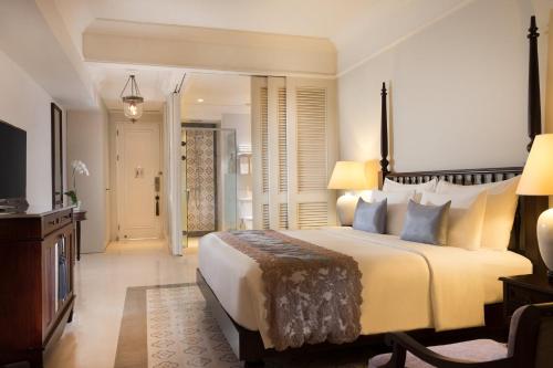a hotel room with a large bed and a television at Rumah Luwih Bali in Keramas