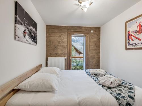 une chambre avec un grand lit blanc avec une fenêtre dans l'établissement DIFY Appartement Luxe - Saint Gervais, à Saint-Gervais-les-Bains