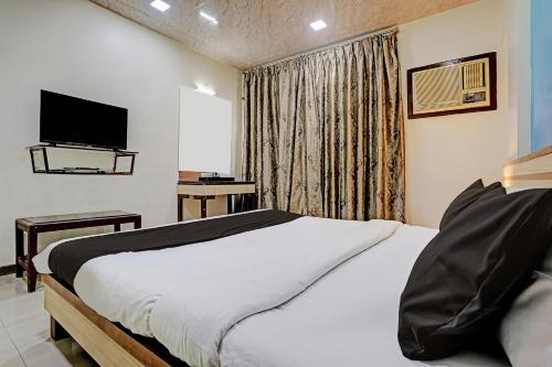 a hotel room with a bed and a television at Collection O Guru Heritage Kalamboli in Mumbai