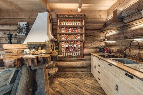 a kitchen in a log cabin with a sink at Domek Między Dolinami in Witów