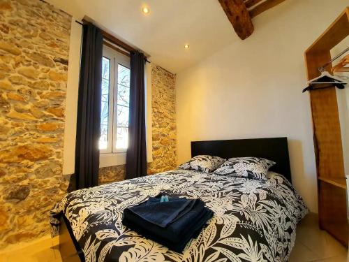 a bedroom with a bed and a stone wall at Freshly tastefully renovated apartments in heart of old Antibes in Antibes