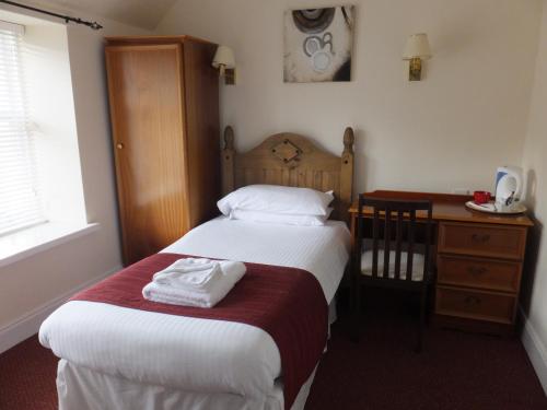Llit o llits en una habitació de Novar Arms Hotel