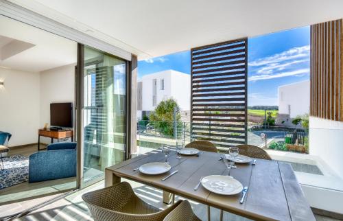 a dining room with a table and chairs and a large window at Santorini Taghazout - T2 luxe-piscine - 3 or 4 Px in Tamraght Ouzdar