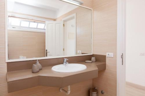 y baño con lavabo y espejo. en Apartamento con vistas al mar golf piscina bbq, en San Miguel de Abona