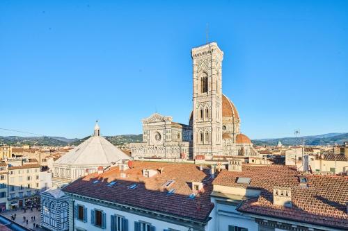 a view of a city with a clock tower and roofs at Duomo Luxury Florence in Florence