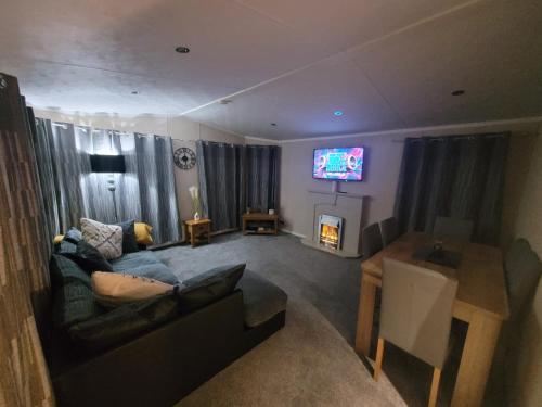 a living room with a couch and a tv at Cherry Blossom Retreat in Felton