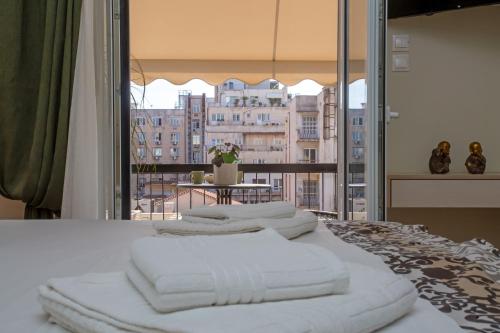 - un ensemble de serviettes blanches assises au-dessus d'un lit dans l'établissement Nefeli by Heloni Apartments, à Athènes