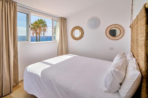 ein weißes Schlafzimmer mit einem großen Bett und einem Fenster in der Unterkunft Encanto Costero Bungalow Acogedor en Golf del Sur, Tenerife in San Miguel de Abona