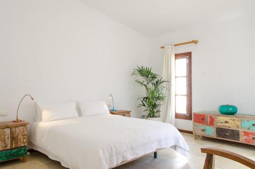 Habitación blanca con cama y ventana en Bungalow frente al mar golf piscina, en San Miguel de Abona