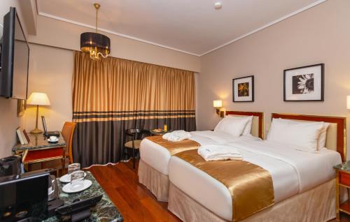 a hotel room with a bed and a television at Ilisia Hotel Athens in Athens