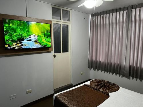 a bedroom with a tv on the wall and a bed at Costa Bella in Ilo