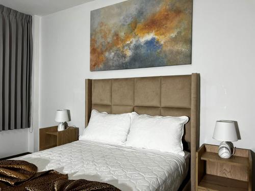 a bedroom with a bed with a painting on the wall at Costa Bella in Ilo