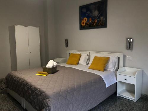 a bedroom with a large bed with yellow pillows at Flower Inn Marconi Roma in Rome