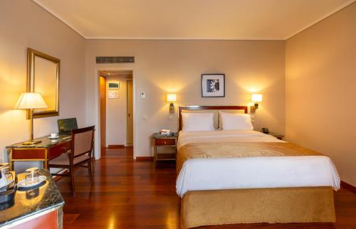a hotel room with a bed and a desk at Ilisia Hotel Athens in Athens