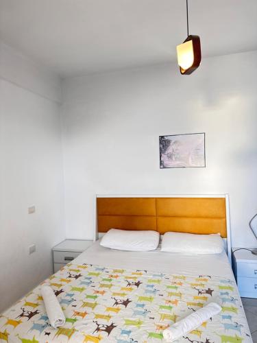 - une chambre avec un lit et une tête de lit en bois dans l'établissement Deep Blue Sea View Apartments, à Saranda