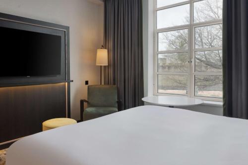 a hotel room with a bed and a large window at Hilton Cardiff in Cardiff