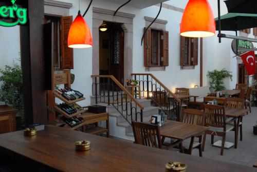 a restaurant with wooden tables and chairs and stairs at Aliye Hanim Hotel in Ayvalık