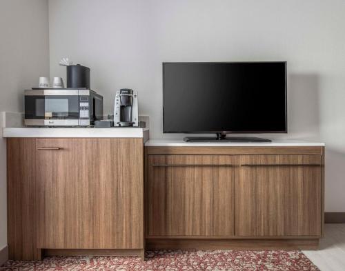 a television on top of a wooden cabinet with a microwave at Hilton Garden Inn Dallas/Allen in Allen