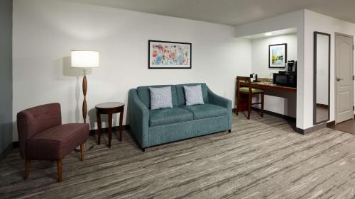 a living room with a couch and a chair and a desk at Hilton Garden Inn Merrillville in Merrillville