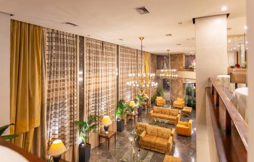 um átrio do hotel com cadeiras e mesas amarelas em Ilisia Hotel Athens em Atenas