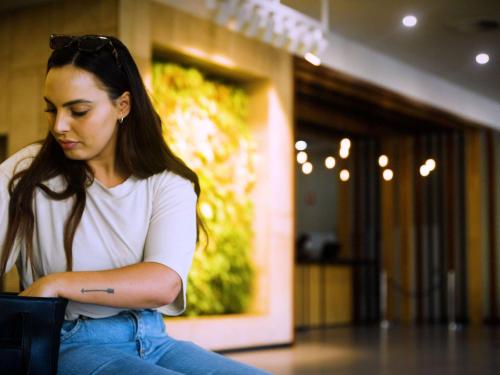 a woman sitting on the floor with her arms crossed at Ibis Styles Hobart in Hobart