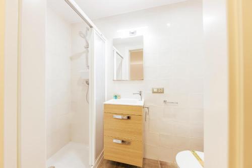ein weißes Bad mit einem Waschbecken und einer Dusche in der Unterkunft Bravissimo Mercadal, one-bedroom plus sofa bed in Girona