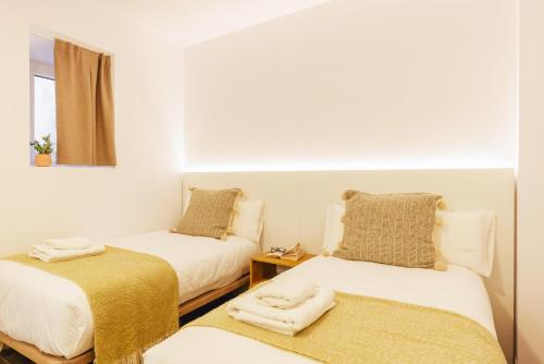 Zimmer mit 2 Betten und einem Spiegel in der Unterkunft Bravissimo Mercadal, one-bedroom plus sofa bed in Girona