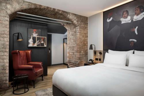 Pokój hotelowy z łóżkiem i krzesłem w obiekcie Radisson RED Hotel, Liverpool w Liverpoolu