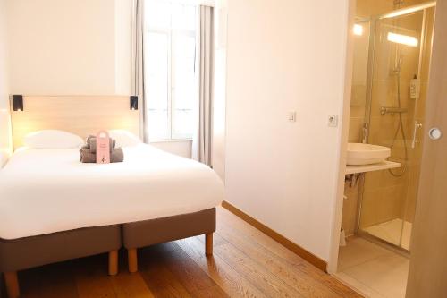 a room with a bed and a bathroom with a shower at HOTEL AMBASSADEUR in Lille