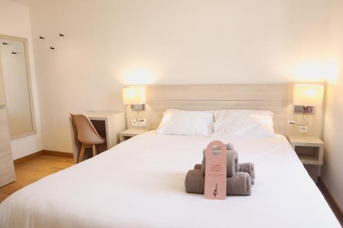 a bedroom with a bed with two teddy bears on it at HOTEL AMBASSADEUR in Lille