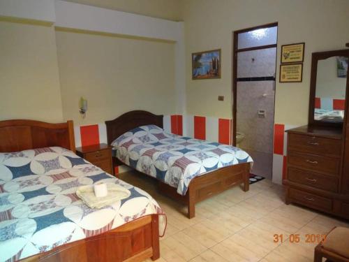 1 dormitorio con 2 camas y vestidor en HOSTAL FAMILIAR FG, en Cochabamba
