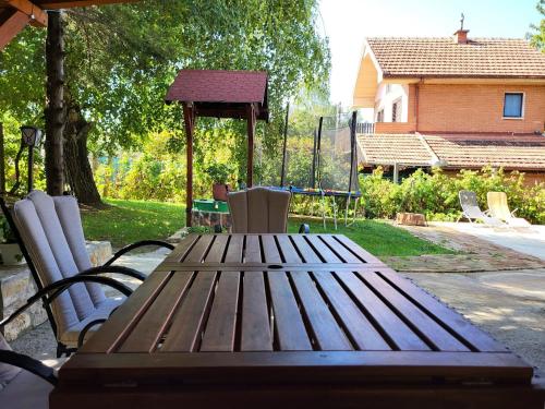 a wooden picnic table with chairs and a gazebo at Vila Mila Fruška Gora in Velika Remeta