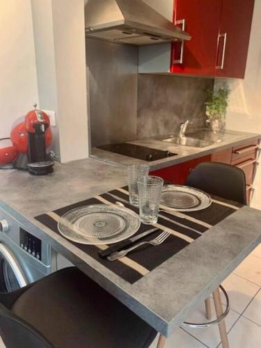 une cuisine avec une table avec des assiettes dessus dans l'établissement * Au P'tit Cosy *, à Dijon