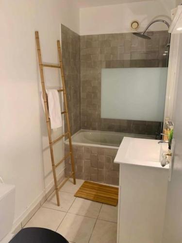 une salle de bain avec une baignoire et un lavabo dans l'établissement * Au P'tit Cosy *, à Dijon