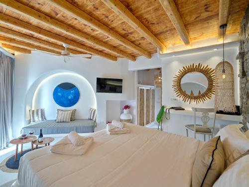 a large bedroom with a large bed and a mirror at Zefi Hotel & Suites in Naousa