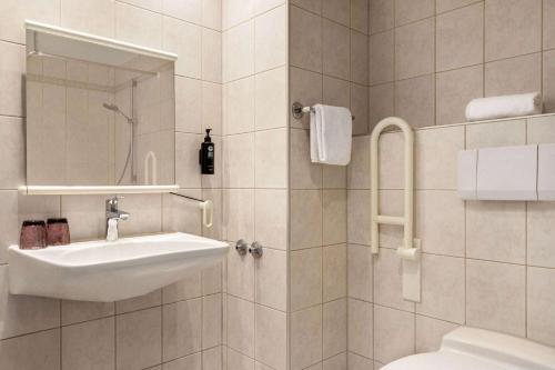 a white bathroom with a sink and a toilet at Vienna House Easy by Wyndham Coburg in Coburg
