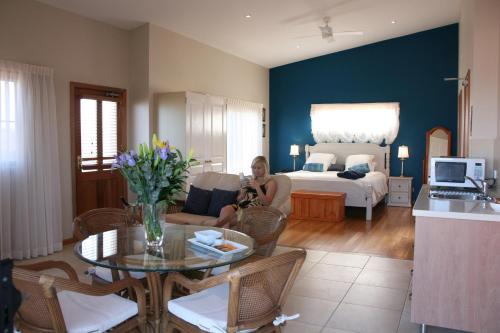 a woman sitting on a couch in a living room at Lavender House Bed & Breakfast in The Entrance