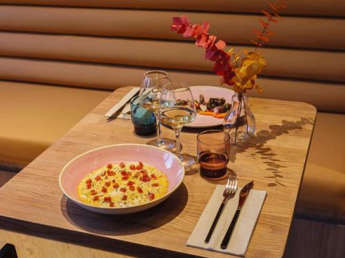 a table with a bowl of food and glasses of wine at TRIBE Lyon Croix Rousse in Lyon