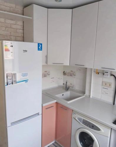 Il comprend une petite cuisine équipée d'un réfrigérateur blanc et d'un lave-vaisselle. dans l'établissement VIP apart 500, à Tbilissi