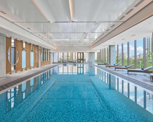 a swimming pool in a building with windows at Hyatt Place Yantai Development Zone in Yantai