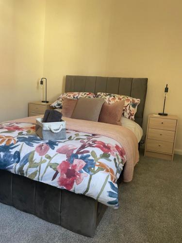 a bedroom with a bed with a floral comforter at The Butcher's Flat Seahouses in Seahouses
